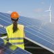 A female engineer is standing beside the solar panel